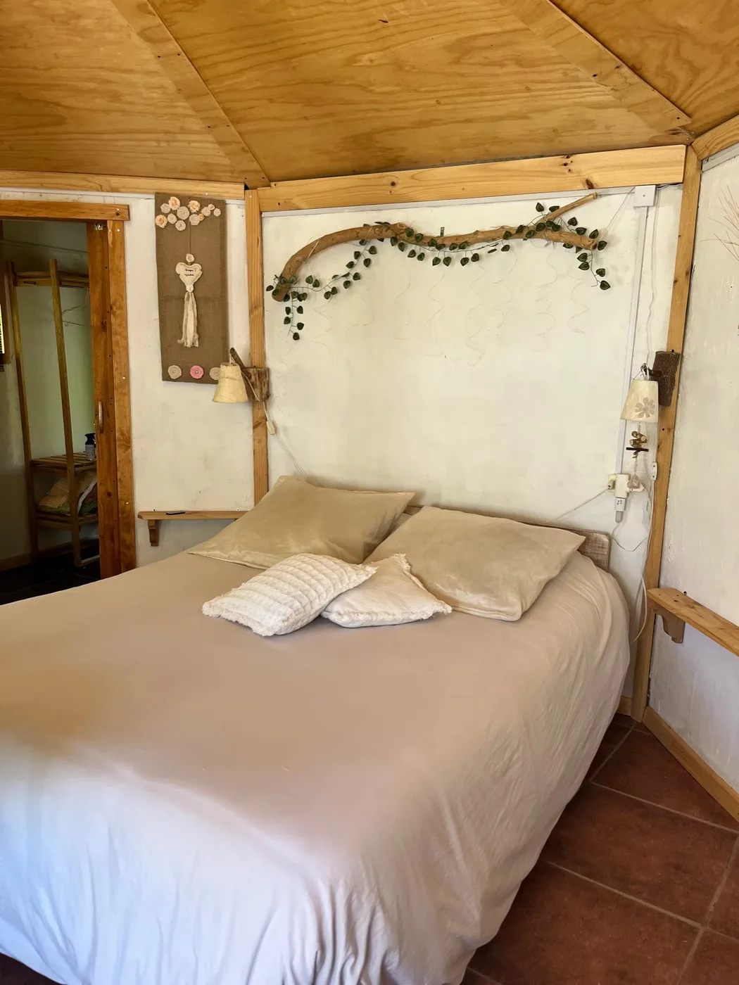 La cama vista de lado, con la puerta abierta al fondo