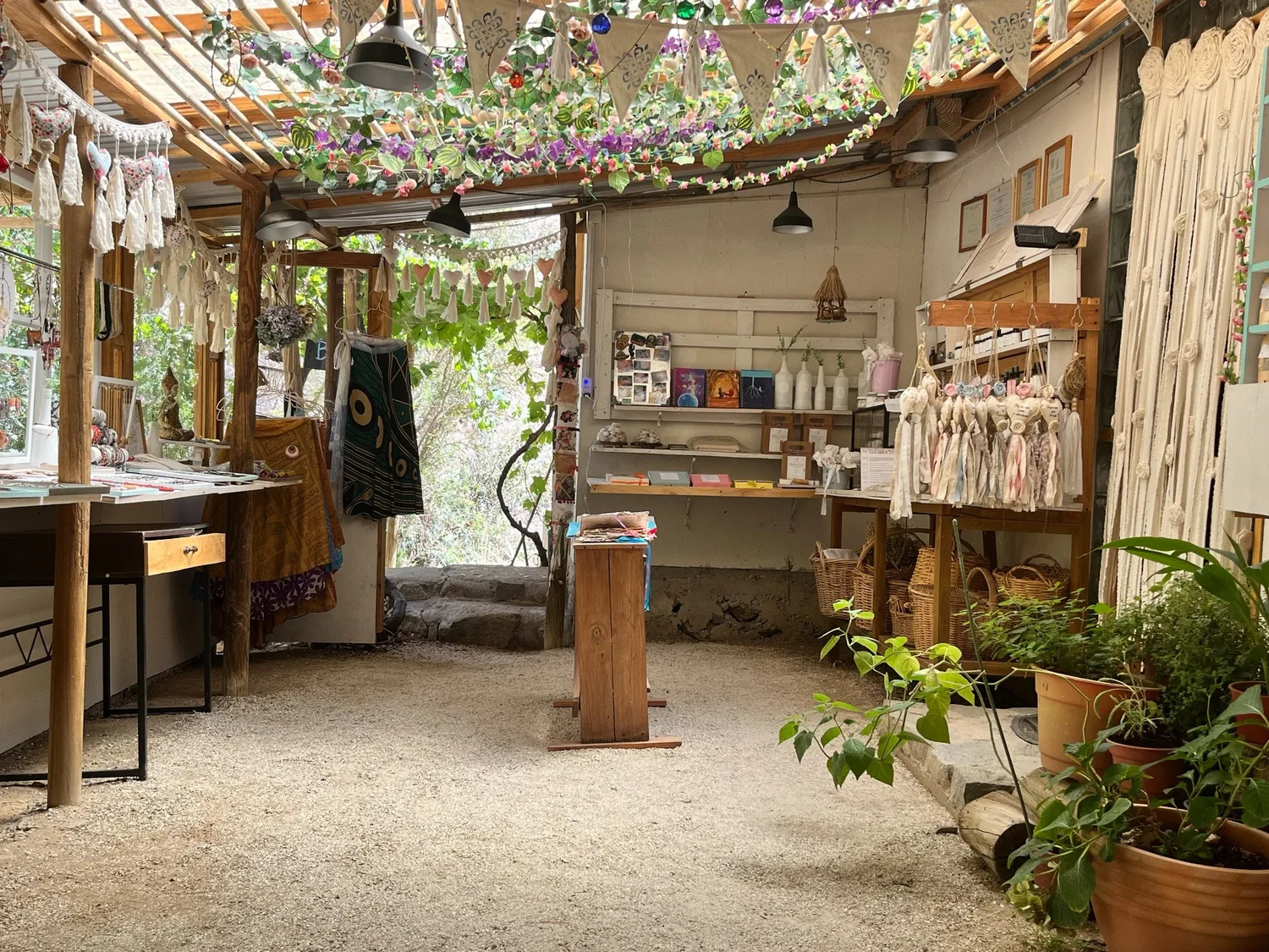El interior de la tienda: mesones con piezas, canastas de mimbre y guirnaldas de flores en el techo